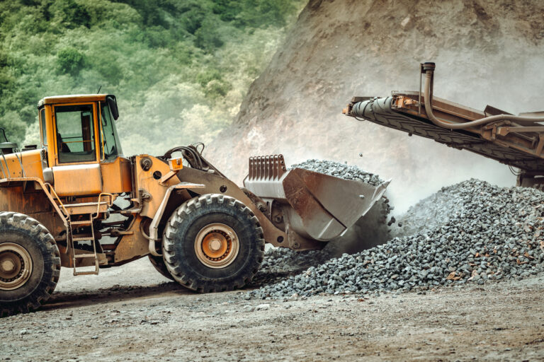 Industrial  wheel loader working on site. Close up of wheel loader working, unloading gravel